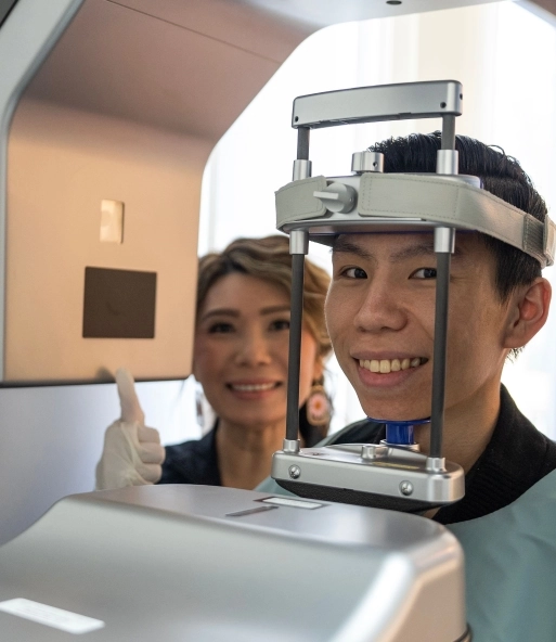 A young man receiving a dental X-ray, assisted by the dental assistant.