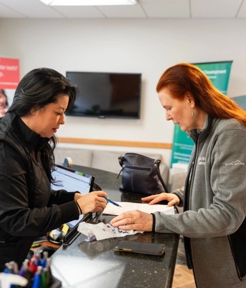 Two women completing a dental insurance form together