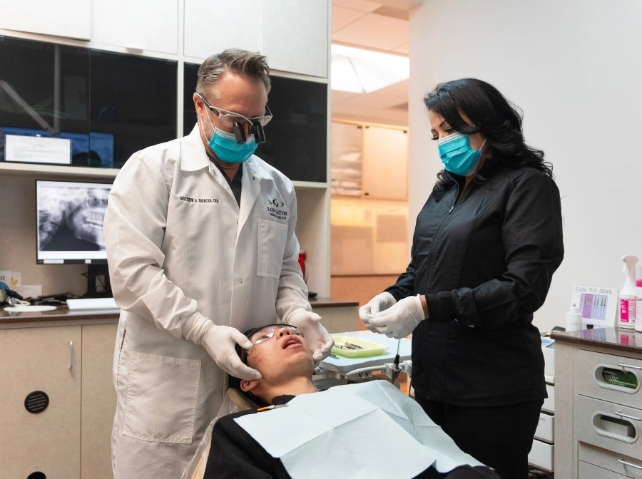 Dentist examining a patient with the assistance of a dental hygienist